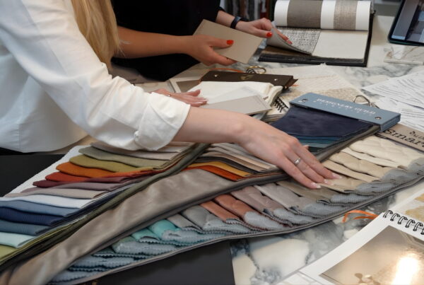 Reviewing colourful fabric and textile samples across a studio table, selecting materials for an interior design project in Galway, Ireland.