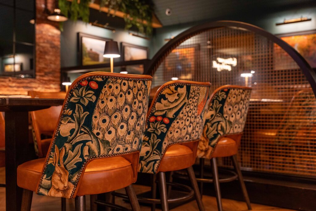 43-Ther Earl Inn (1) Close-up of patterned upholstery fabric on restaurant dining chairs at The Earl Inn, supplied by The Design Barn fabric studio.
